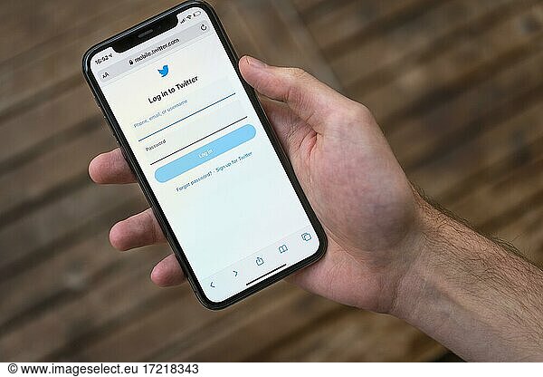 Hand hält iPhone 11 Pro mit geöffneter Twitter Website  Login  Soziales Netzwerk  Logo  Smartphone