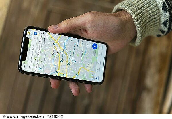 Hand hält iPhone 11 Pro mit Google Maps App  Online Karten Dienst  Bildschirmfoto  Smartphone