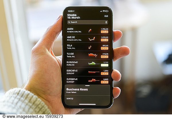 Hand holds iPhone 11 with stock app on display  iOS  Smartphone  Germany  Europe