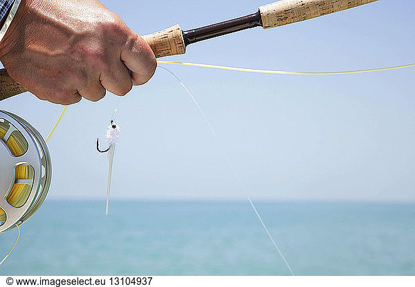 Hand of a fly fisherman preparing to cast for tarpon in Florida  USA