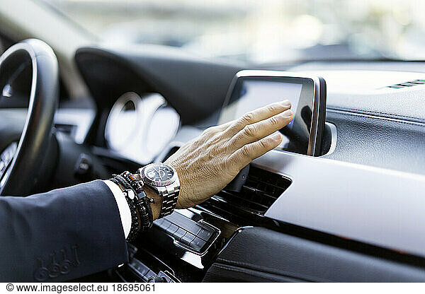 Hand of businessman using GPS system in car