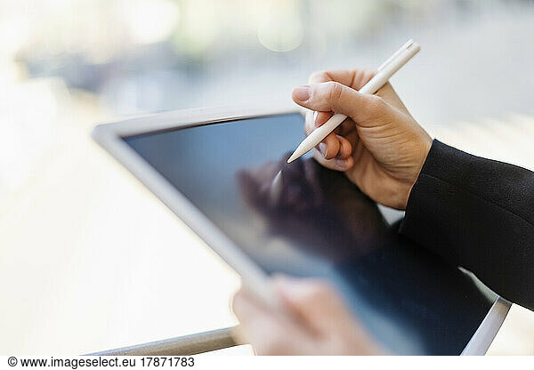 Hand of businesswoman holding digitized pen drawing on tablet PC