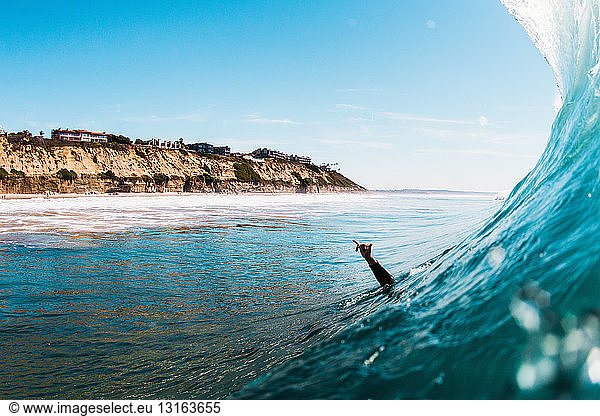 Hand of male surfer raised in sea  Encinitas  California  USA