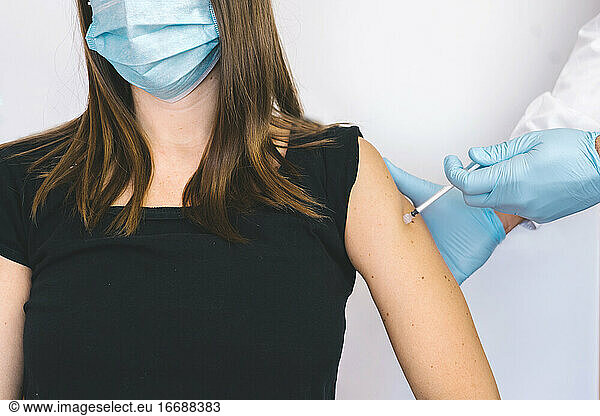 hand of medical staff in blue glove injecting coronavirus covid-19 vac