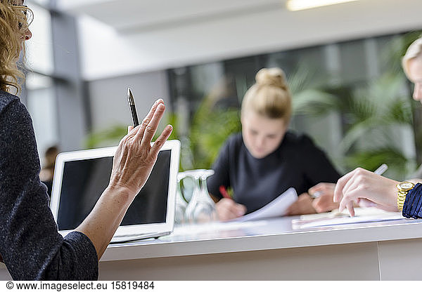 Hand of senior businesswoman  holding pen in a meeting
