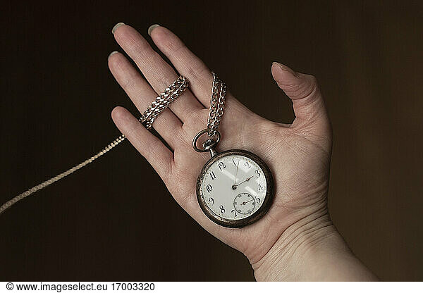 Hand of woman holding antique pocket watch