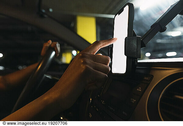 Hand of woman using mobile phone in car