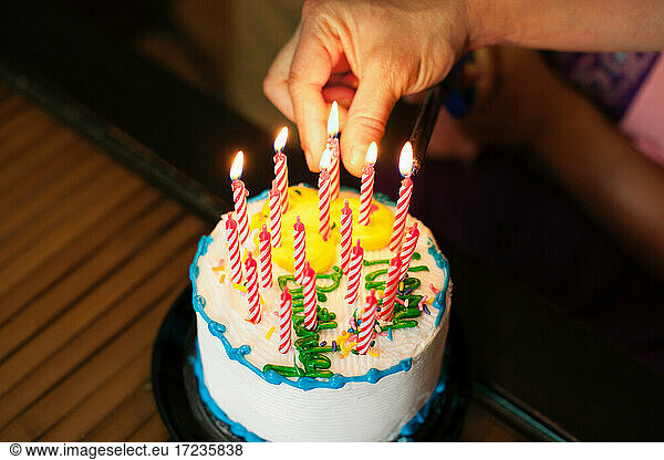 Hand putting candles into cake