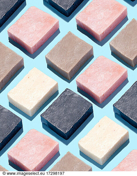 Handmade Soap Arranged in Pattern on Blue Background Pink Tan Charcoal