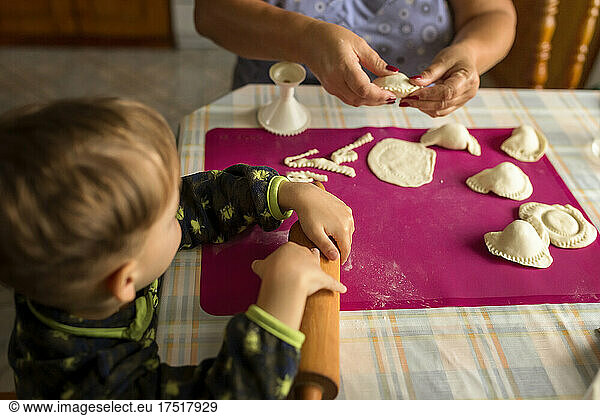 Hands of a woman and child making traditional polish food