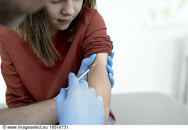 Hands of doctor giving vaccination to patient in clinic