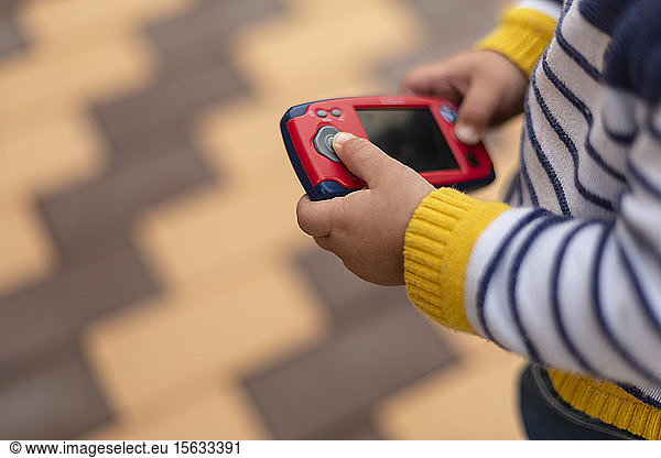 Hands of little boy holding toy mobile phone  close-up