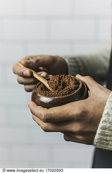 Hands of man holding bowl of cocoa powder