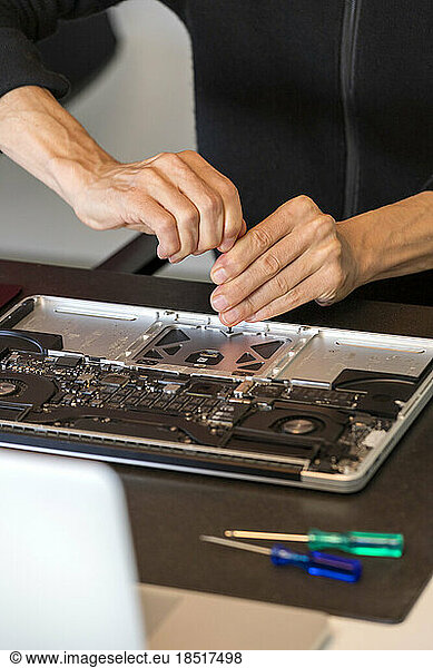 Hands of man repairing laptop