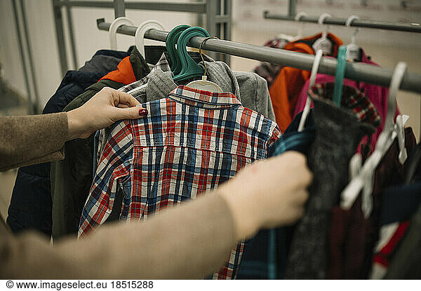 Hands of woman choosing clothes at store
