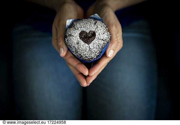 Hands of woman holding Valentines Day muffin
