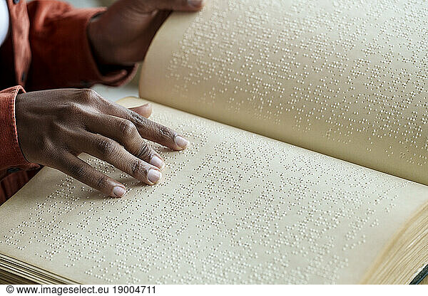 Hands of woman reading braille text