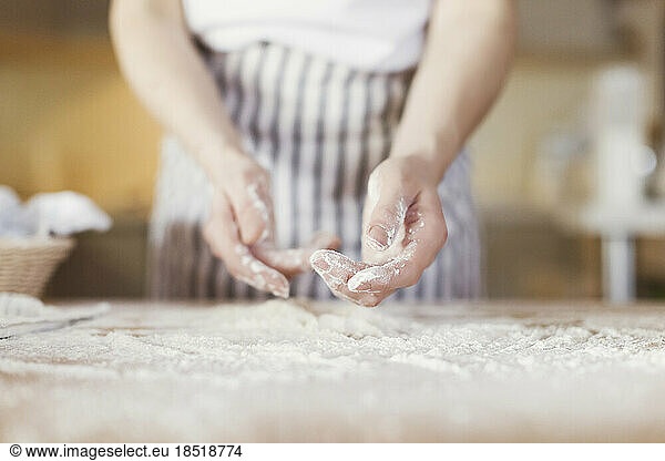 Hands of young woman covered in flour