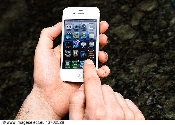 Hands touching the screen of an iPhone.