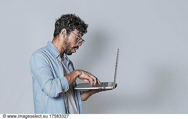 Handsome Kerl seinen Laptop isoliert  überrascht Mann seinen Laptop zu überprüfen  Kerl mit Laptop