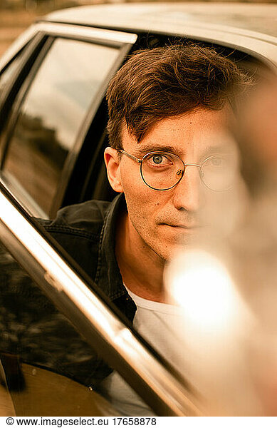 handsome man in glasses in car