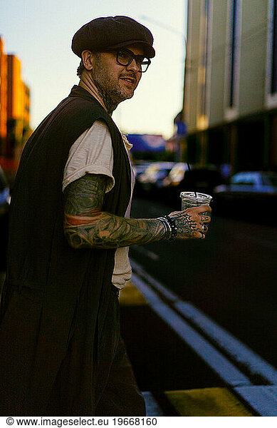Handsome man in the city drinks coffee  tattooed man.