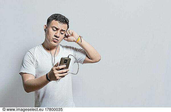 Handsome man listening to music with his cell phone with headphones isolated  people enjoying music with headphones isolated  cheerful guy listening to music with his cell phone isolated