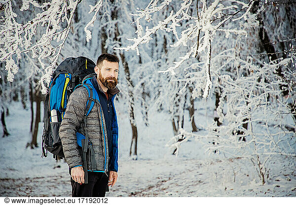 handsome man trekking in beautiful winter landscape social dista