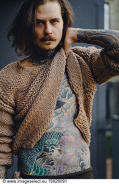 Handsome tattooed sexy man with long hair and mustache outdoors