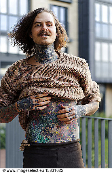 Handsome tattooed sexy man with long hair and mustache outdoors