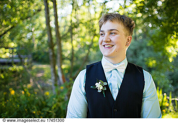 Handsome young man smiling  looking away outdoors.