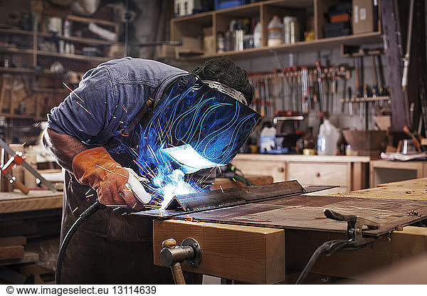 Handwerker schweißt Metall in der Werkstatt