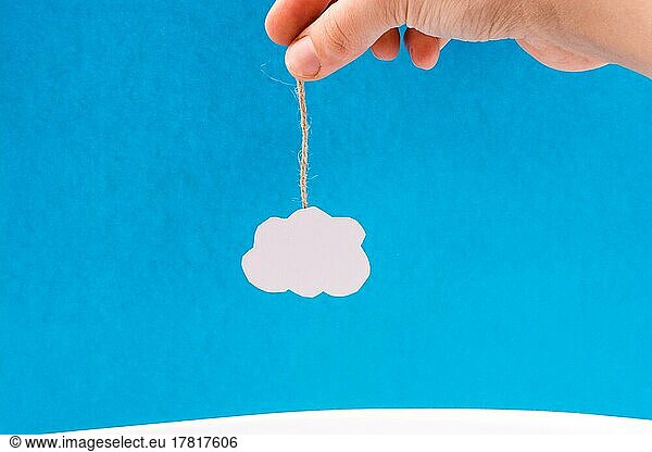 Hanging cloud held by a hand on a blue background