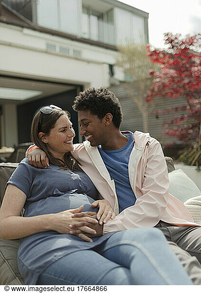 Happy affectionate pregnant couple on patio