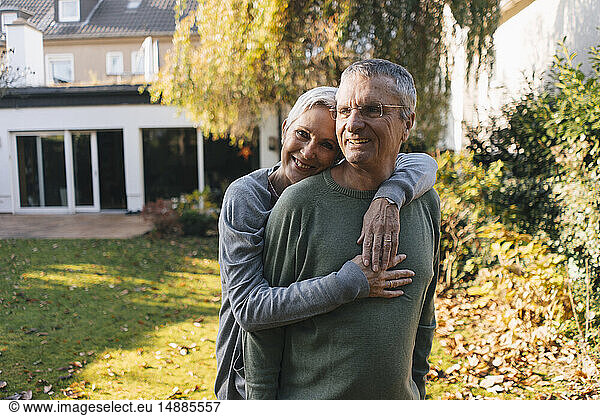 Happy affectionate senior couple hugging in garden
