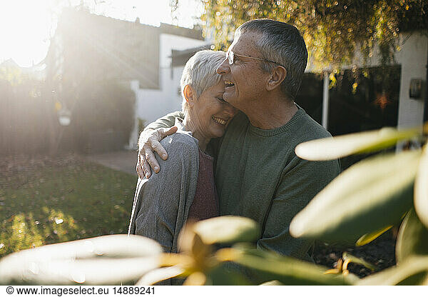 Happy affectionate senior couple hugging in garden