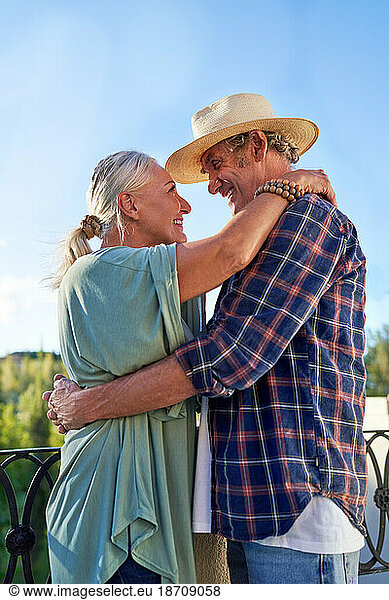 Happy  affectionate senior couple hugging on balcony