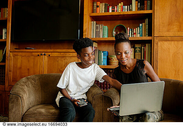 Happy African American boy & mom with laptop during distance learning