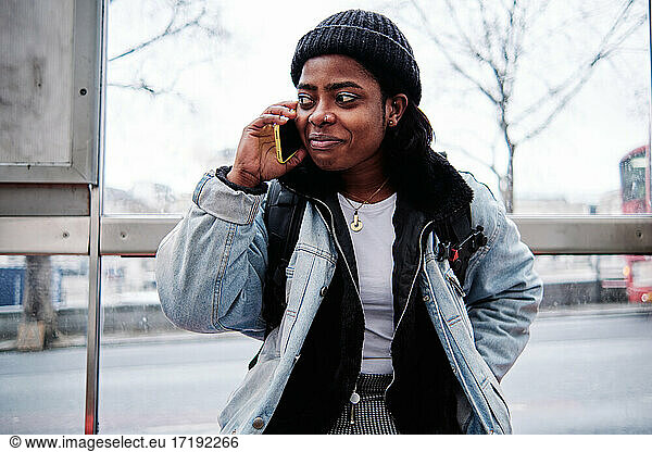 happy african american young woman talking with cellphone in city