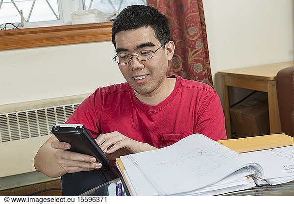 Happy Asian man with Autism using a phone