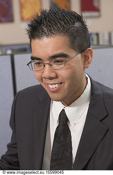 Happy Asian man with Autism working in an office