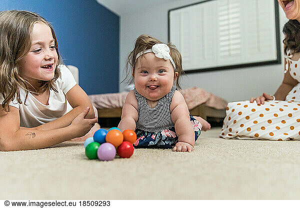 Happy baby with down syndrome playing inside