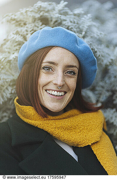 Happy beautiful redhead woman wearing yellow scarf and blue beret