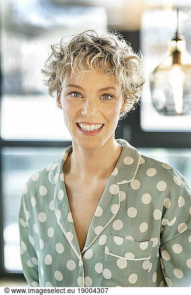 Happy blond businesswoman with short hair in office