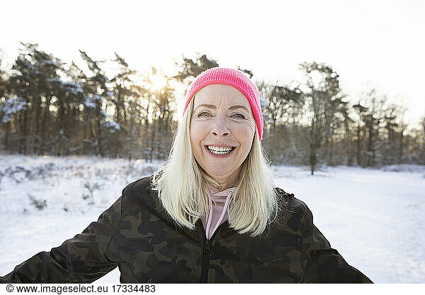Happy blond woman wearing pink knit hat