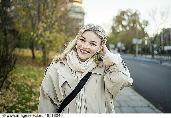 Happy blond woman with hand in hair