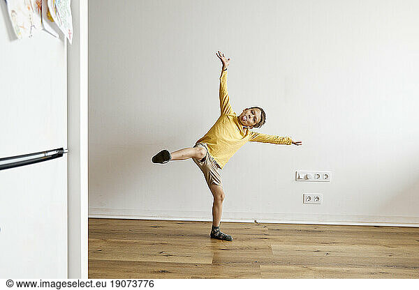 Happy boy doing mischief and having fun in front of white wall