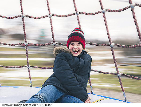 Happy boy enjoying in merry-go-round at playground