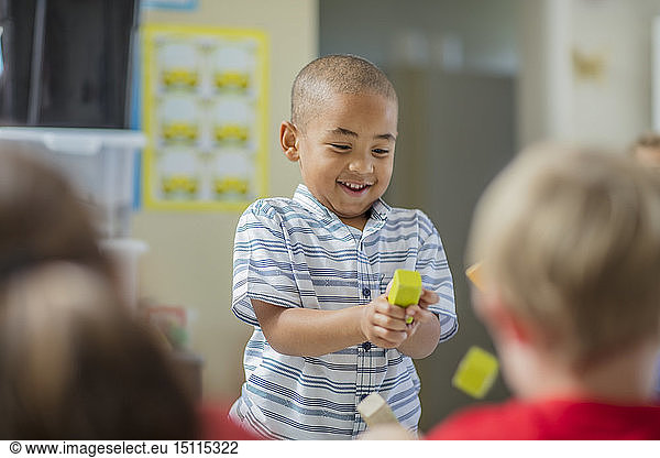 Happy boy playing with other children in kindergarten