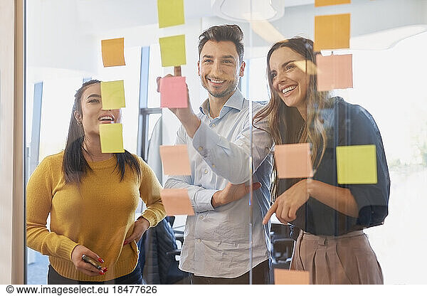 Happy business colleagues discussing in brainstorming session at office